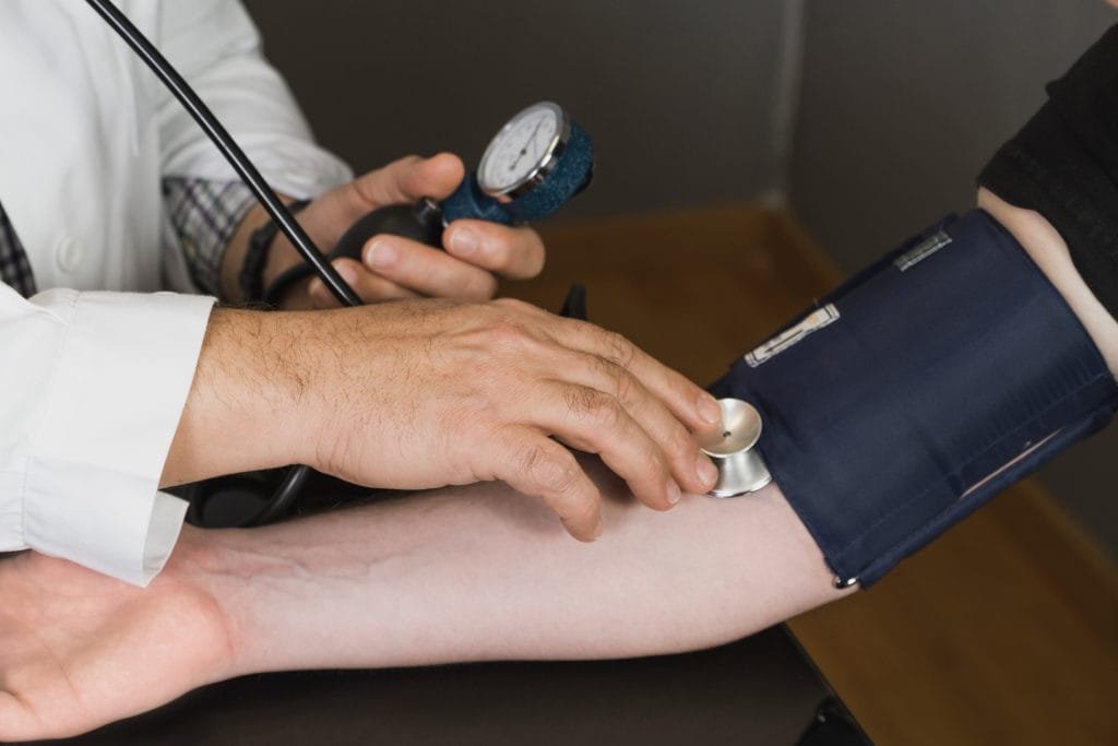 Doctor checking patient's blood pressure
